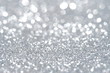 Silver Sparkling Lights Festive background with texture. Abstract Christmas twinkled bright bokeh defocused and Falling stars. Winter Card or invitation	