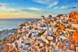 Oia village Thira Santorini Greece with sunset and blue sky.