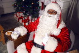 Fototapeta Do akwarium - African-American Santa Claus in room decorated for Christmas