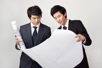 young businessmen holding blueprints