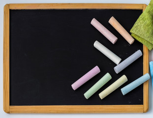 Colored pencils are placed on a black children's drawing Board with a copy of the space