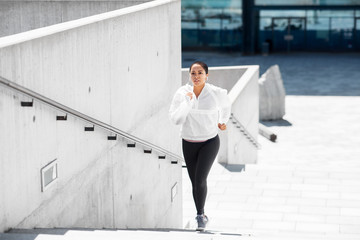 fitness, sport and healthy lifestyle concept - young african american woman running upstairs outdoors