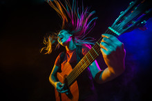 Playing Guitar. Young Woman With Smoke And Neon Light On Black Background. Highly Tensioned, Wide Angle, Fish Eye View. Concept Of Human Emotions, Facial Expression, Sales, Ad, Sport.