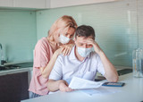 Fototapeta  - Serious stressed couple worried about unpaid bank debt calculate bills, shocked poor family looking at calculator counting loan payment upset about money problem during the pandemic coronavirus