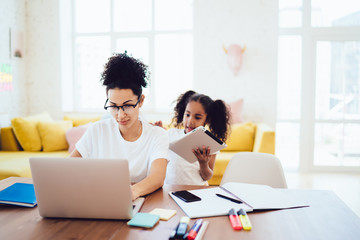 Ethnic kid distracting mother from work