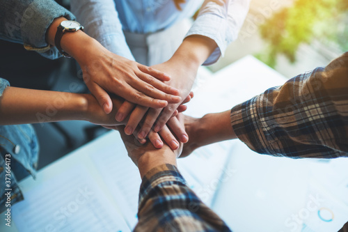 Fotografía Closeup image of business team standing and joining their hands together in offi