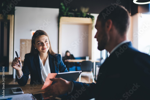 Fotografía Young female employee listening to team leader explaining new strategy in office