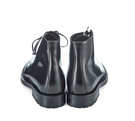 Classic black plain toe boots made of durable glossy leather with a small lace-up heel, isolated on a white background with a shadow. Rear view.