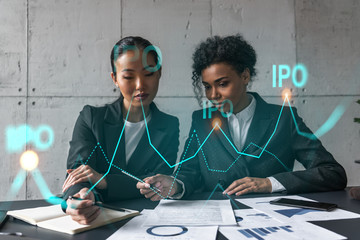 Two businesswomen work together in modern office on new project. Double exposure. Concept of success. IPO symbol icon.