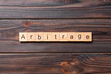 Arbitrage word written on wood block. Arbitrage text on cement table for your desing, concept