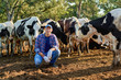 © JENOCHE - Happy male farmer on cow farm around herd .