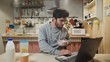 © stanis88 - Business man working laptop computer and eats Corn Flakes Cereal at home kitchen.