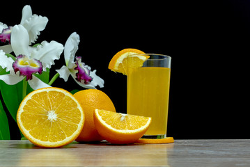 Orange juice in a glass and an orange fruit on the ground