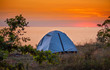 Namiot na tle wschodzącego słońca na plaży morza Bałtyckiego 