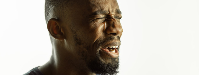 Wall Mural - Crying. African-american young man's close up shot on studio background, flyer. Concept of human emotions, facial expression, sales, ad. Copyspace. Beautiful male model with bright expression.