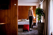 © BGStock72 - Young businesswoman arrives in a hotel room with red suitcase