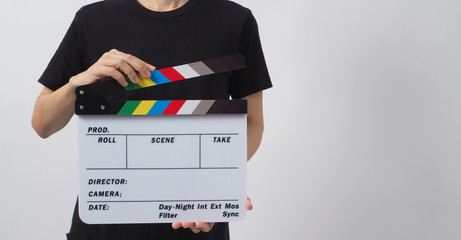 Hand is holding clapper board or movie slate and standing on white background. it is used in video production and film industry.