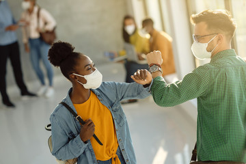 Poster - Happy university students greeting with elbow while wearing protective face masks.