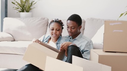 Wall Mural - A young wife is packing boxes with her husband. The couple are moving. This is a consept of people's relocation