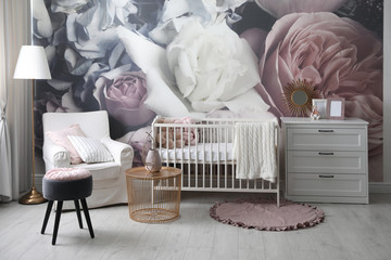 Baby room interior with stylish crib and floral wallpaper