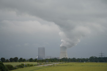 Coal power plant polluting the planet, thick chimney smoking towards the sky.