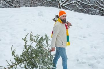 Wall Mural - Santa Claus with Christmas tree. Bearded Man cutting Christmas tree. Young woodcutter winter portrait. Winter emotion. Happy winter time.