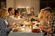 © Syda Productions - holidays, celebration and people concept - happy friends having christmas dinner party and drinking non-alcoholic red wine at home