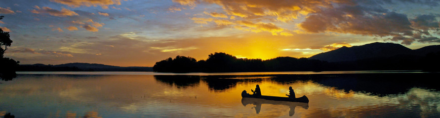 canoe on a lake at sunset