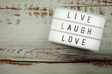 Live Laugh Love Word In Light Box Flat Lay On Wooden Background