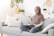 © Prostock-studio - Happy Arabic Housewife Relaxing With Book And Coffee On Couch At Home