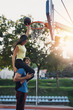 © hedgehog94 - Beautiful young couple enjoying together and playing on basketball court. Bright sunny summer day.