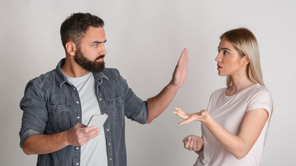 Wall Mural - Control and jealousy in relationship. Home tyrant checks wife phone