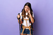 © luismolinero - Young woman with backpack and trekking poles isolated on purple background thinking an idea