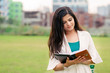 © Abhishek Kumar Sah - A beautiful Asian/ Indian girl is reading a book or diary in outdoor location.