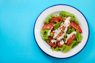 Sticker - fresh salad with grilled chicken and sauce on the plate