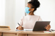 © Prostock-studio - Black Schoolgirl In Surgical Mask Sitting Using Tablet In Classroom
