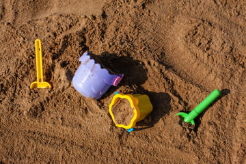 Sandbox with children's buckets and shovels. Playing in the sandpit on the beach.