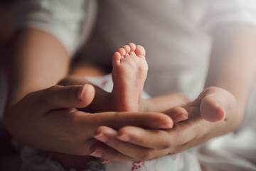 Wall Mural - parent holding in the hands feet of newborn baby.