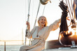 © Artem Varnitsin - Happy senior woman sitting on a private yacht and pointing way