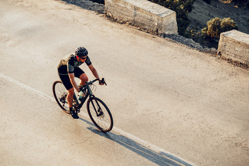 Wall Mural - Professional cyclist on a mountain road at sunrise