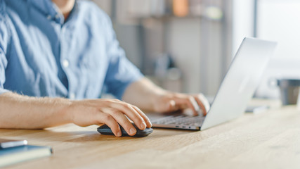 Poster - Anonymous Businessman Sitting at the Wooden Desk and Working on a Laptop, Typing and Writing Business Email, Designing Software, Browsing Internet. Focus on Hands and Notebook