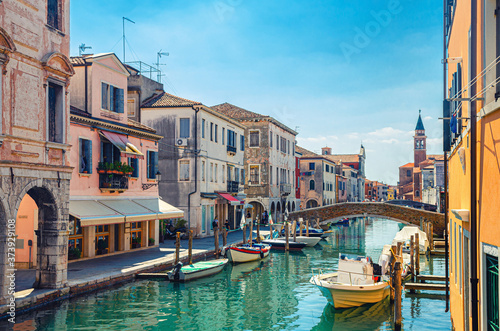 Fotomural Chioggia cityscape with narrow water canal Vena with moored multicolored boats b