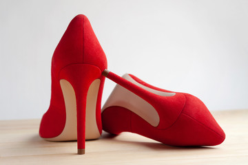 Red female shoes on a wooden floor.