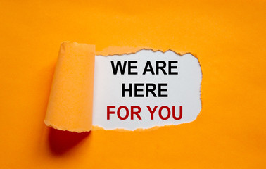 Wall Mural - The text 'we are here for you' appearing behind torn orange paper. Business concept. Copy space.