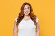 Smiling beautiful charming young redhead plus size body positive female woman girl 20s in white blank design casual t-shirt posing looking camera isolated on yellow color background studio portrait.