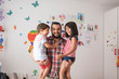 © Antonio Recena - Father lifts his children in children's bedroom and looks at camera smiling