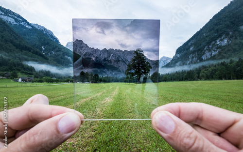 Cuadros en Lienzo Professional photographer holding ND Gradient Filter glass appreciating an effect
