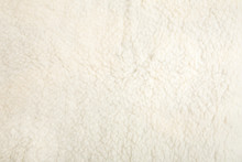 Top View Of White Soft Sheepskin Textile Plaid. Warm Cozy Background.