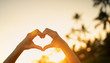 © kieferpix - Hand making heart shape on beautiful sunset background.