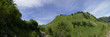Panorama grüne Hügel mit Weg und blauem Himmel mit Wolken